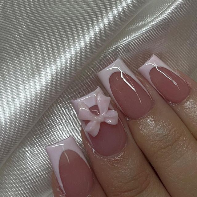 Elegant Chic French Tip Nails with Delicate Pink Bow Accent.