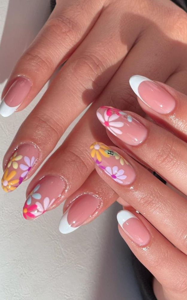 Vibrant Floral Nail Design with Pastel Patterns and Classic French Tips.