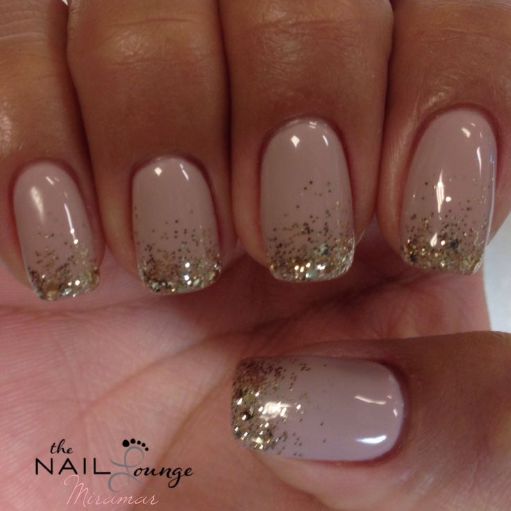 Sophisticated Nude Nail Design with Shimmering Gold Glitter Tips.