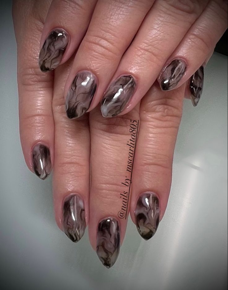 Chic Almond-Shaped Marble Nail Design in Rich Browns and Translucent Shades.