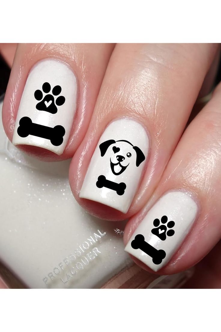 Playful Dog-Themed Nail Design: Black Paw Prints and Cartoon Pup on Creamy White Background.