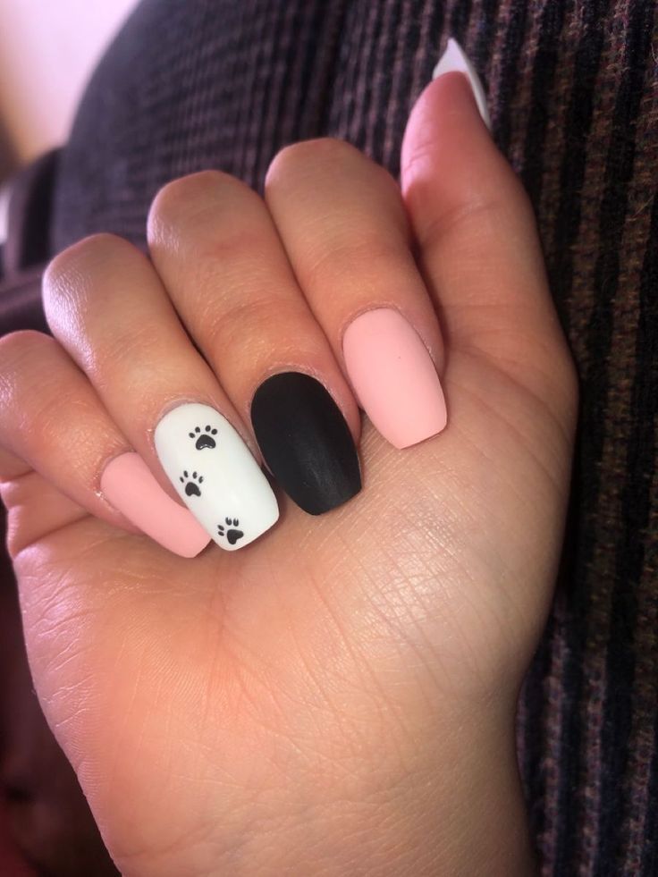 Chic and Playful Nail Design: Soft Pink, Matte Black, and Whimsical Paw Prints for Pet Lovers.