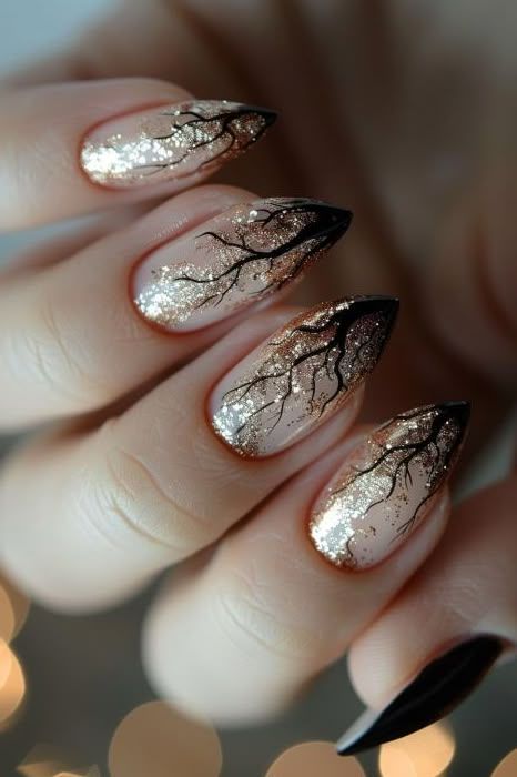 Sophisticated Stiletto Nails: Nude and Metallic Glitter with Artistic Black Branches.