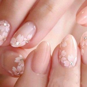 Elegant Floral Nail Art: Soft Pink and Nude Hues with Charming White Accents.