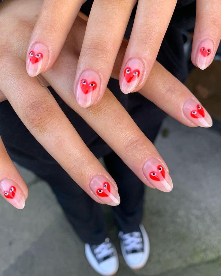 Playful Red Heart Nail Design with Glossy Nude Base and Whimsical Accents.