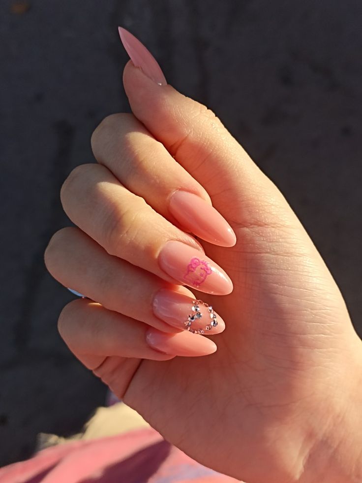 Sophisticated Almond-Shaped Nail Design with Soft Pink Base and Glamorous Accents.