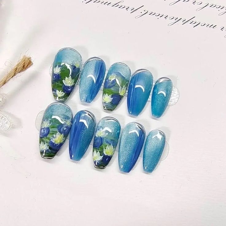 Elegant Floral Nail Design in Blue Shades with Gradient Effects.