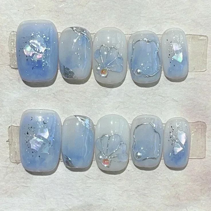 Elegant Pastel Blue Nail Design with Glossy Finishes and Floral Accents