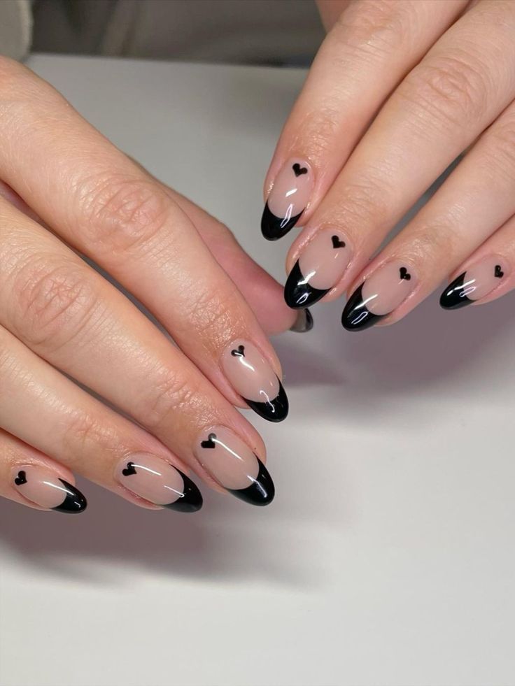 Chic French Manicure with Nude Base, Black Tips, and Playful Heart Accents.