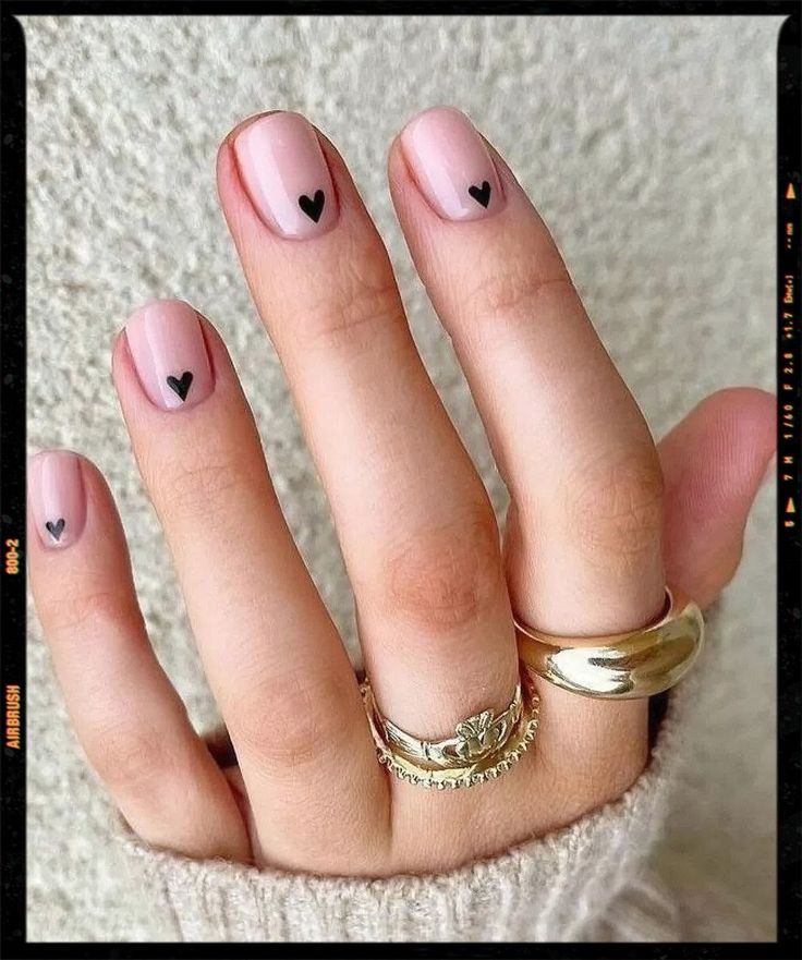 Chic Minimalist Nail Design: Soft Pink Base with Playful Black Heart Accents