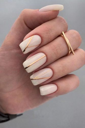 Chic Neutral Nail Design with Glossy Finish and Elegant Golden Accents.