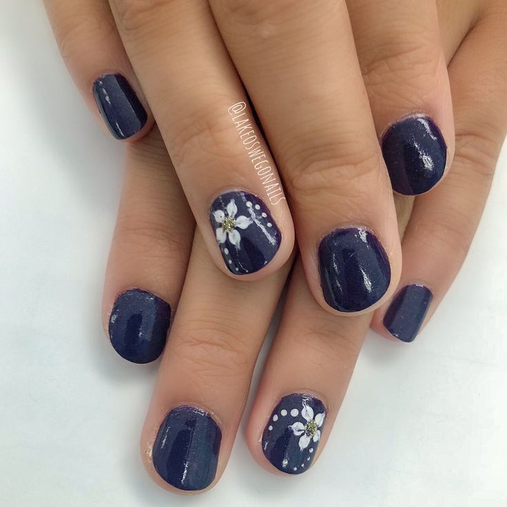 Chic Deep Navy Nail Design with Elegant White Floral Accents for Any Occasion.