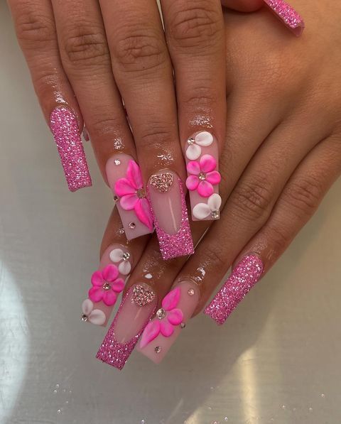 Glamorous Pink Nail Design: 3D Floral Embellishments with Sparkling Accents on a Nude Base