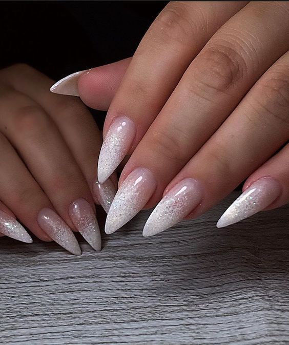 Chic Ombre Stiletto Nails: Sophisticated Glittery Elegance for Any Occasion.