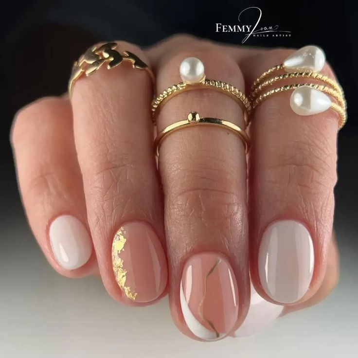 Sophisticated Nude and White Nail Design with Gold Accents and Marble Detailing.