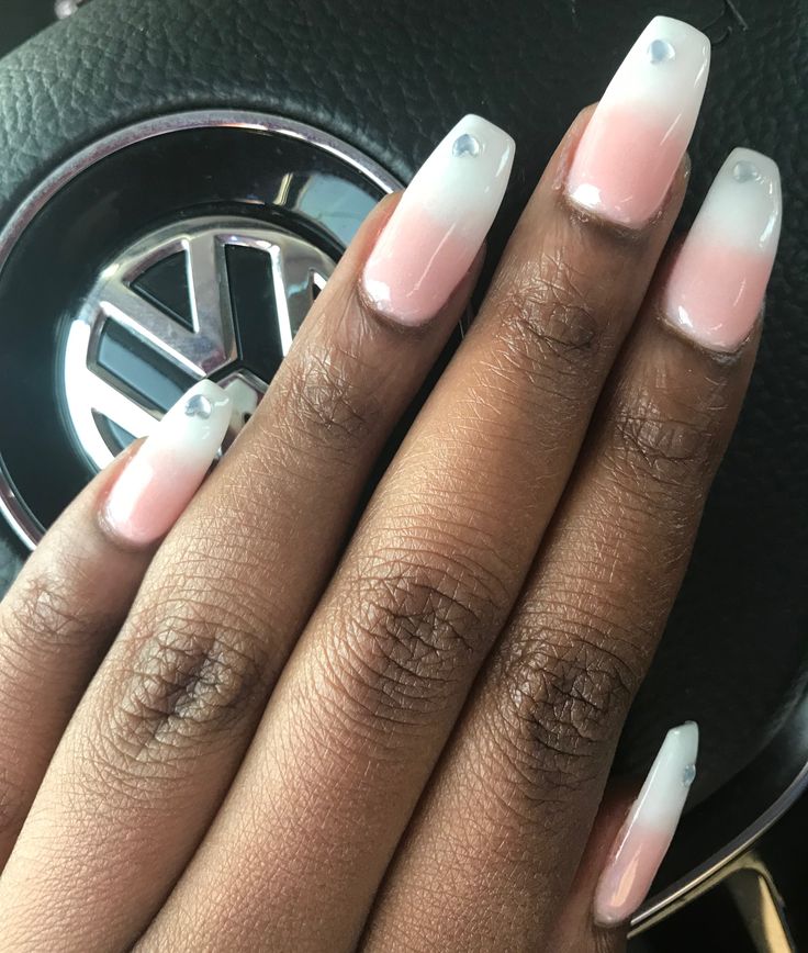 Chic Ombre Nail Design: Soft Pink to Crisp White with Gemstone Accents.