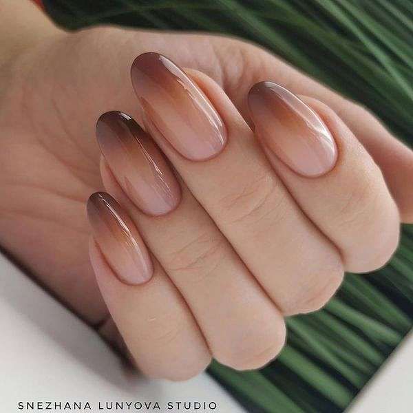 Elegant Ombre Nail Design: Chic Beige to Warm Hue Transition in Almond Shape.