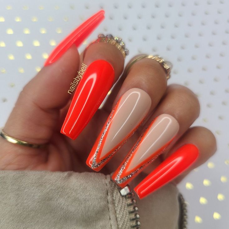 Bold Geometric Orange and Nude Nail Design with Elongated Tips and Sparkling Accents.