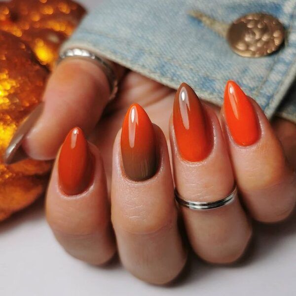 Bold Autumn-Inspired Orange Nail Design with Gradient and Metallic Accents.