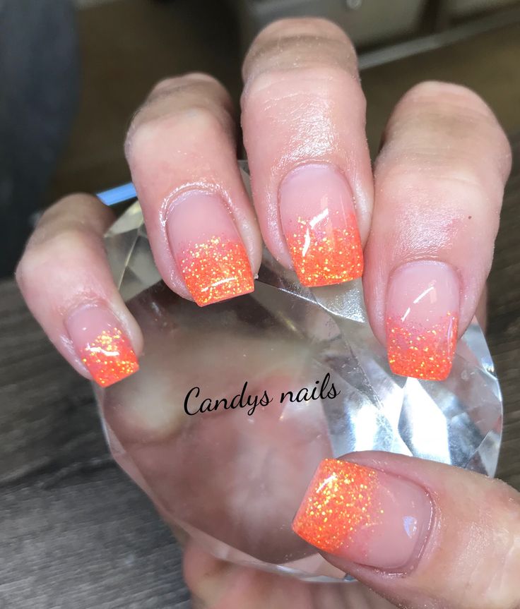 Striking Vibrant Orange Ombre Nails with Glittery Finish for a Playful Touch.