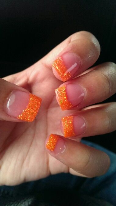 Playful Vibrant Orange Glitter Tips Transform Classic French Manicure for Summer Festivities.