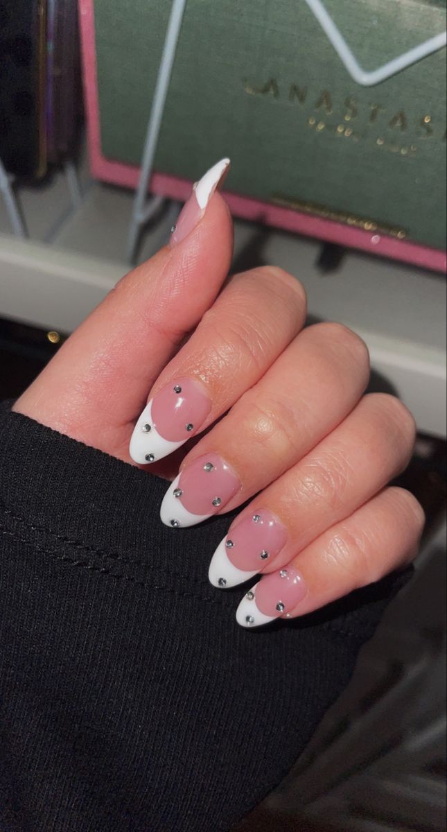 Chic French Tip Nail Design with Translucent Pink Base and Rhinestone Accents.