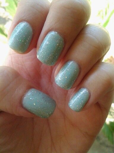 Elegant Shimmering Teal Nail Design with Glossy Finish and Sparkling Accents.