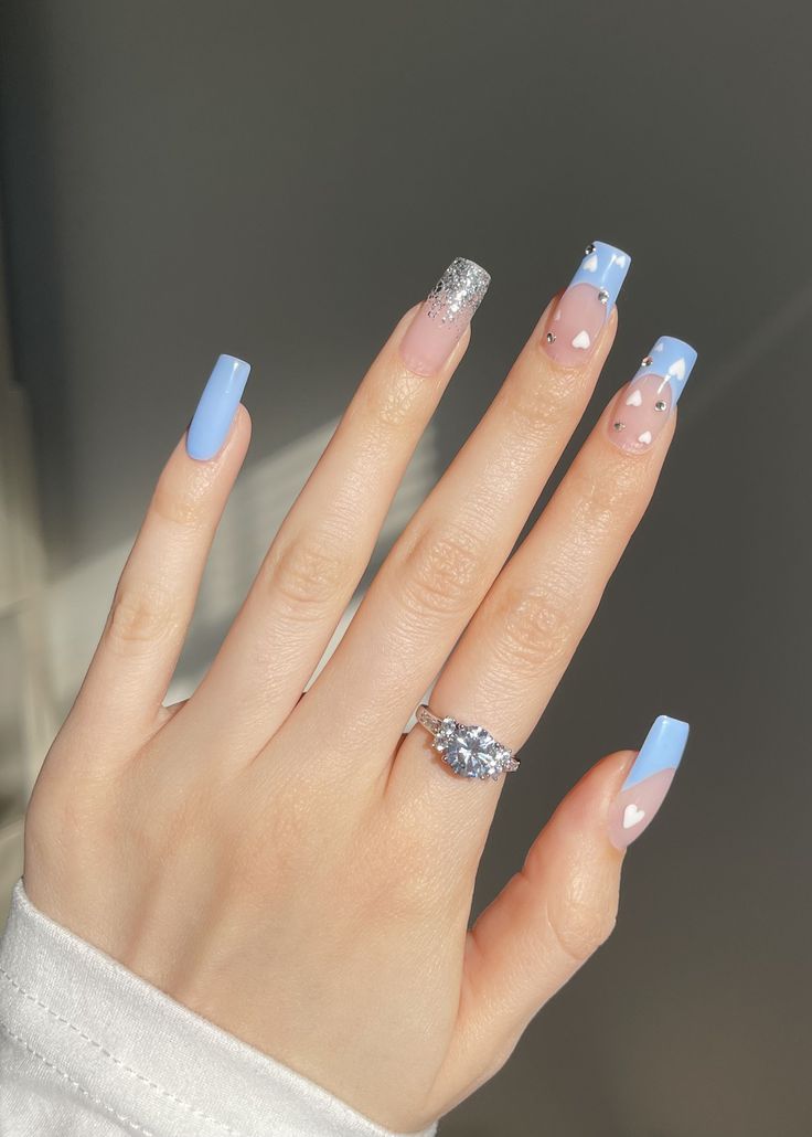 Whimsical Yet Elegant: Pastel Blue and Pink Nail Design with Glitter and Heart Accents.