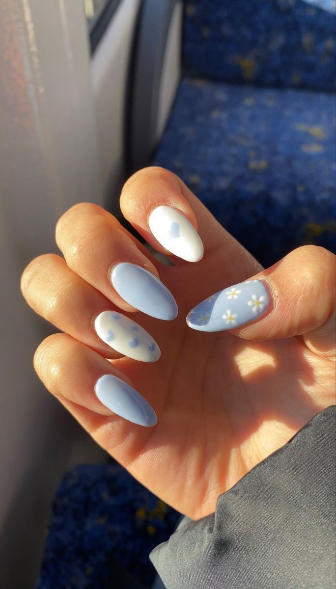 Charming Soft Blue Nail Design with Floral Accents and Varying Finishes for a Fresh, Youthful Aesthetic.