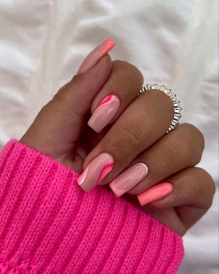 Playful Pink and Coral Nail Design with Elegant Swirls for a Trendy Look.