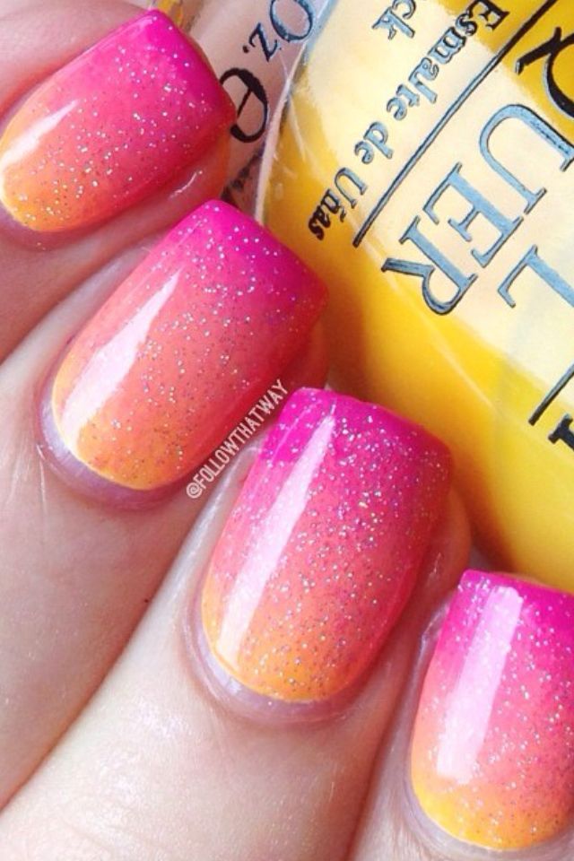 Vibrant Pink and Orange Ombre Nail Design with Sparkle for a Lively Summer Look.