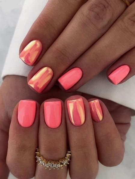 Playful Coral and Peach Nail Design with Metallic Gold Accents for a Vibrant Touch.