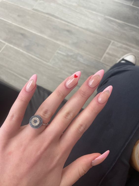 Chic Soft Pink Nail Design with Nude Accents and Playful Red Heart Detail.