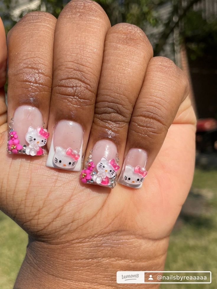 Adorable Hello Kitty Nail Design with Pink Bows and Sparkling Accents.