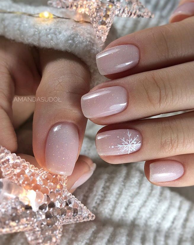 Charming Winter Nail Design with Soft Pink Base, Glitter, and Snowflake Accent.