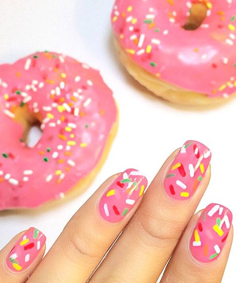 Whimsical Donut-Inspired Nail Design Featuring Bright Pink Frosting and Colorful Sprinkles.