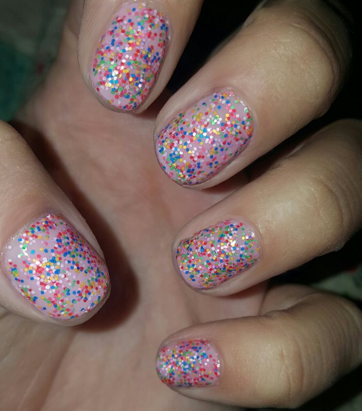 Whimsical Sparkly Nail Design with Colorful Glitter on Sheer Pink Base.