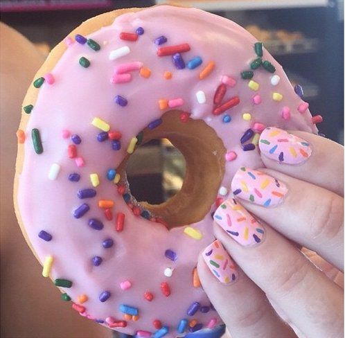 Whimsical Pastel Pink Donut-Inspired Nail Art with Vibrant Sprinkles.