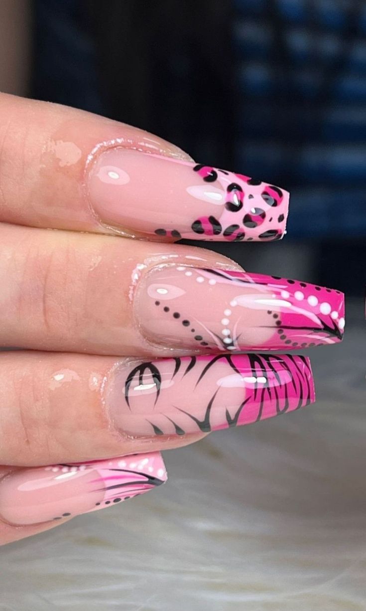 Bold Elongated Nail Art: Striking Pink and Black Designs with Elegant Patterns.