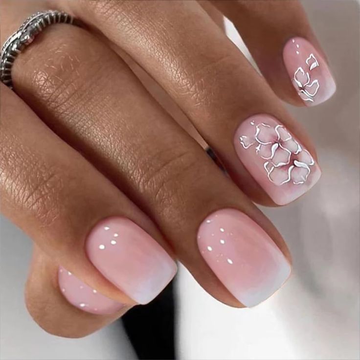 Elegant Pink Gradient Nails with Intricate White Floral Accents.