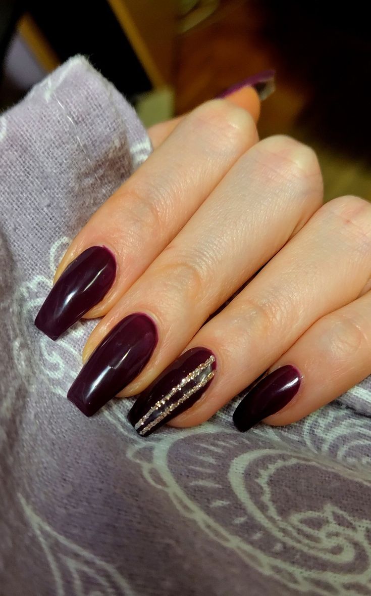 Elegant Deep Burgundy Nail Design with Glamorous Golden Accent.