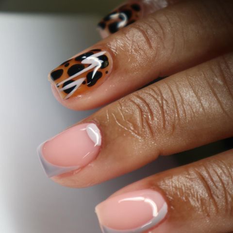 Chic Nail Design: Sophisticated Nude with Bold Animal Print and Playful Swirl Elements