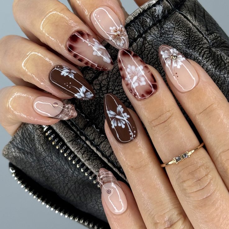 Sophisticated Nude and Brown Manicure with Floral Accents and Glossy Finish