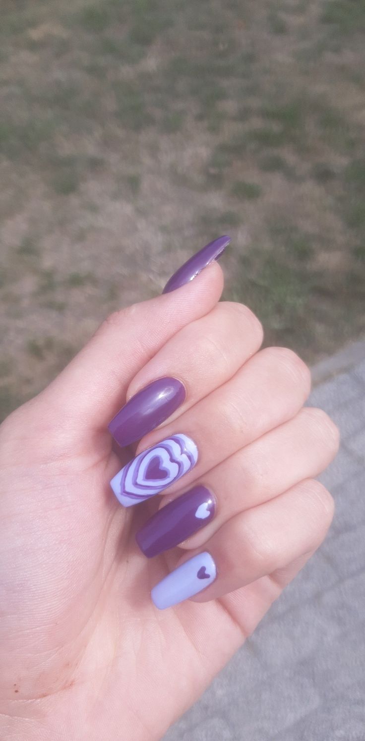 Elegant Nail Design with Deep Purple and Lavender Shades Featuring Playful Heart Patterns.