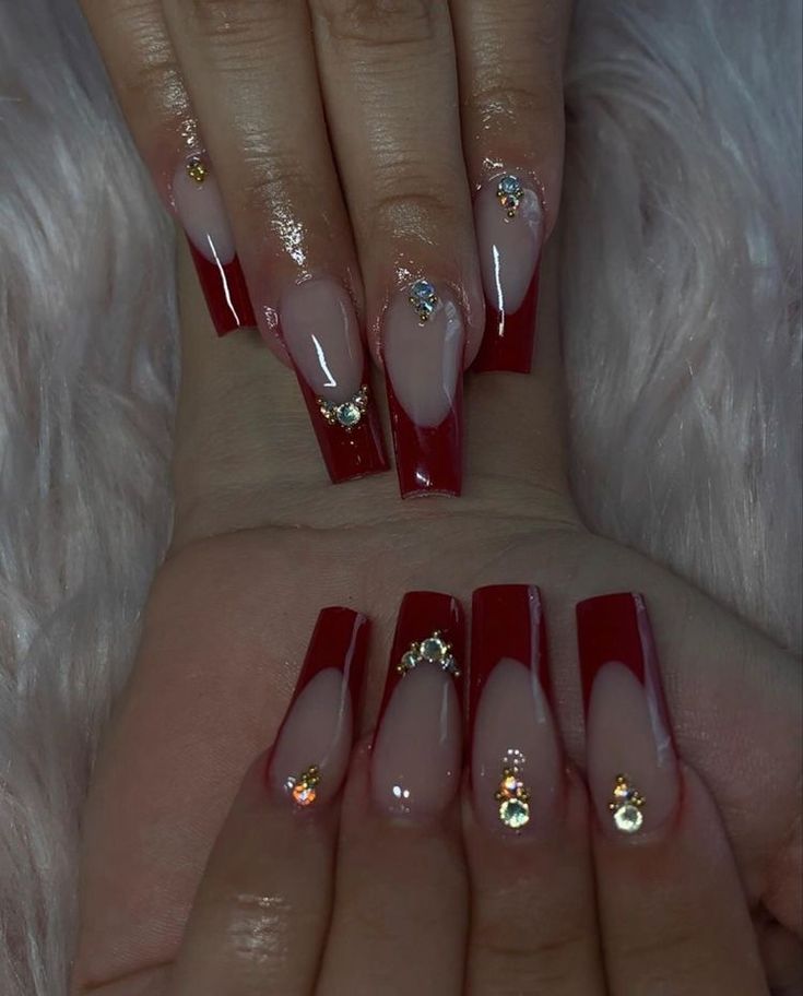 Chic Red and Nude Split Color Nail Design with Sparkling Jewel Accents.