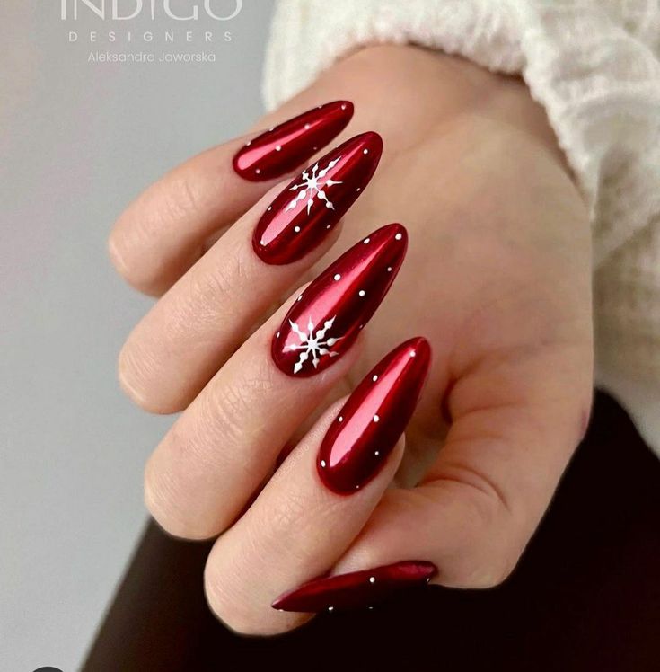 Glamorous Red Stiletto Nails with Intricate Snowflake Designs for the Holiday Season.