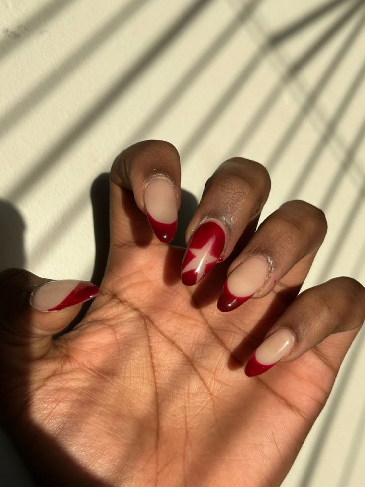 Chic French Twist Nail Design with Neutral and Deep Red Tones and Playful Star Accent.