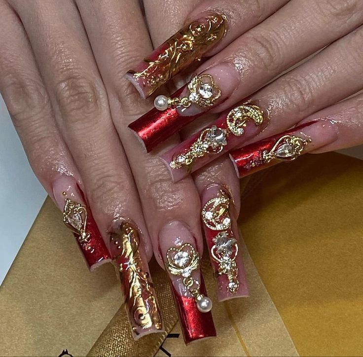 Opulent Red and Gold Nail Art with Intricate Embellishments for Glamorous Occasions