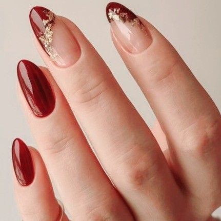 Chic Deep Red and Nude Nail Design with Glamorous Gold Foil Accents.