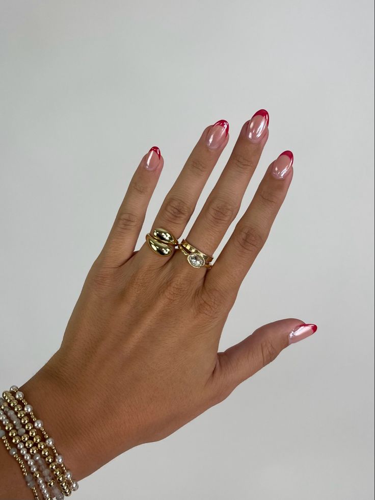 Chic Gradient Manicure: Light Base with Striking Red Tips and Complementary Rings.